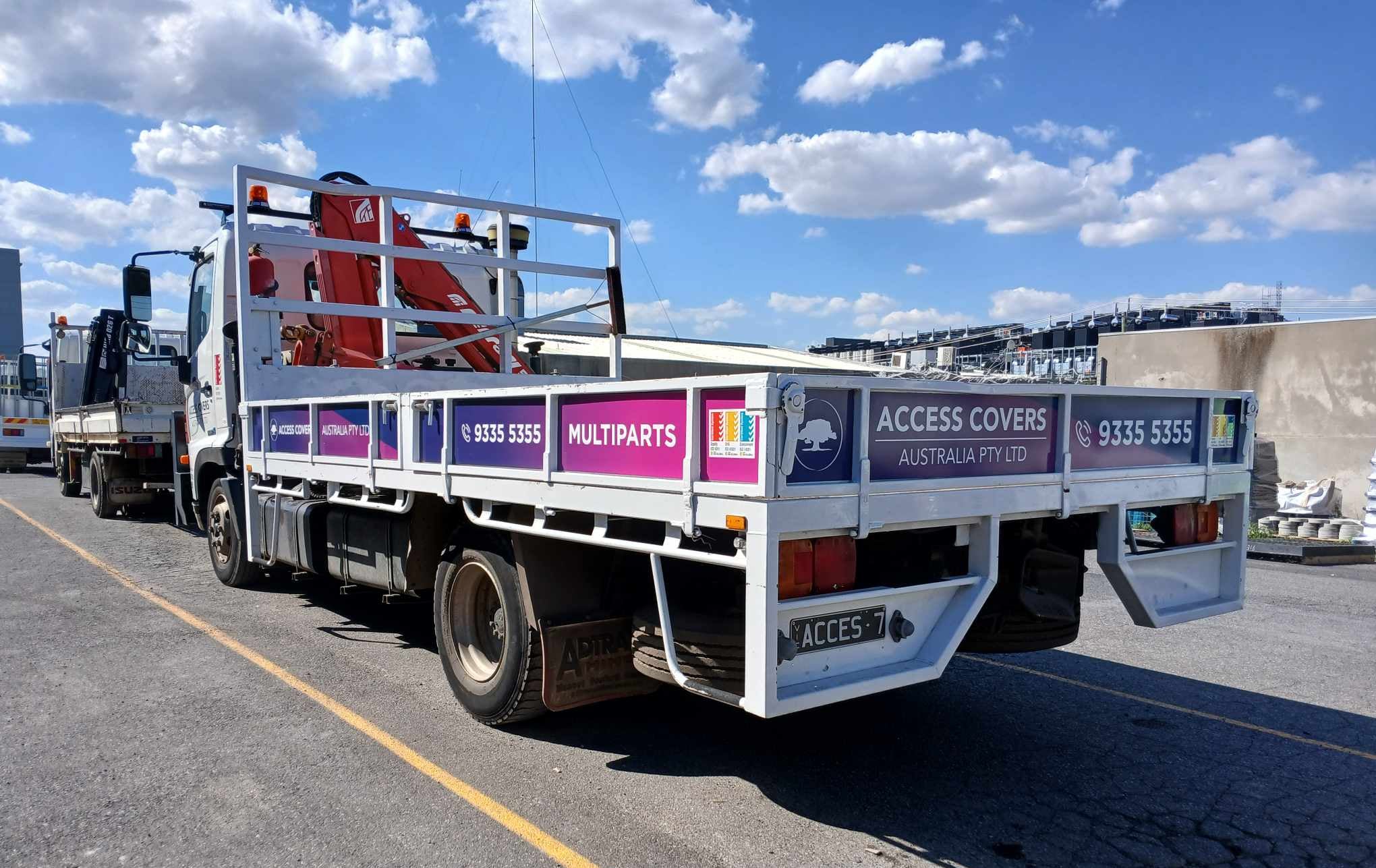 White truck with advertising on a road under a blue sky with clouds