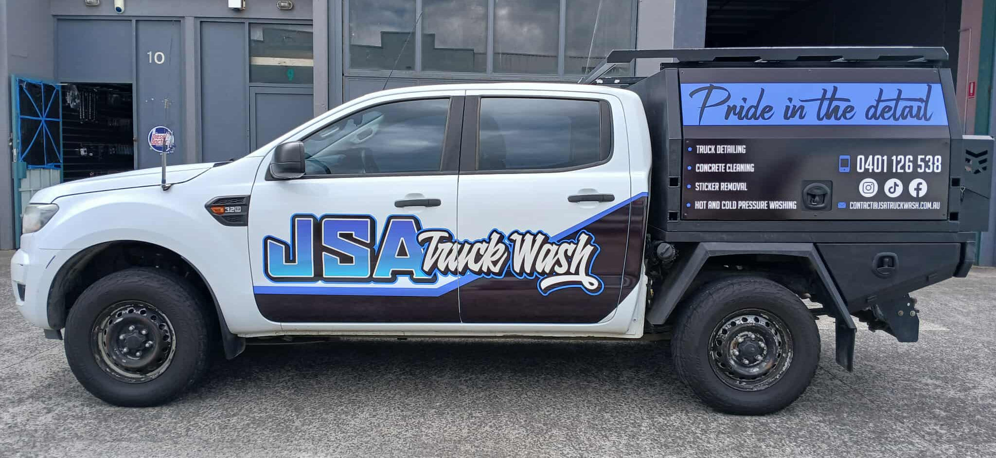 White truck with 'JSA Truck Wash' branding parked in front of a building. Was made in Thomastown using printed viny and panels on canopy. 