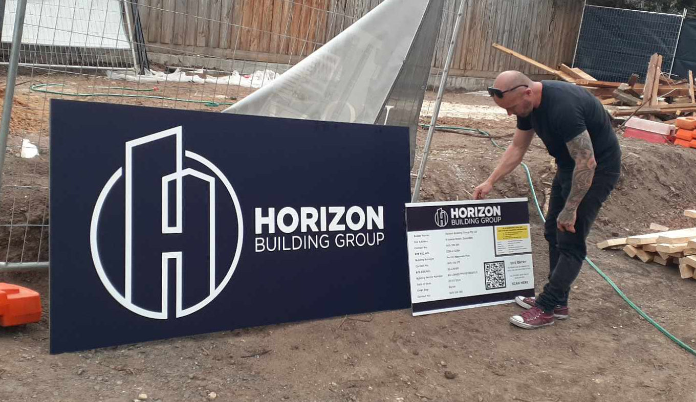 Person working on a construction site with Horizon Building Group sign in the foreground