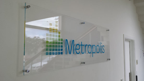 Glass wall with 'Metropolis' logo and staircase reflection