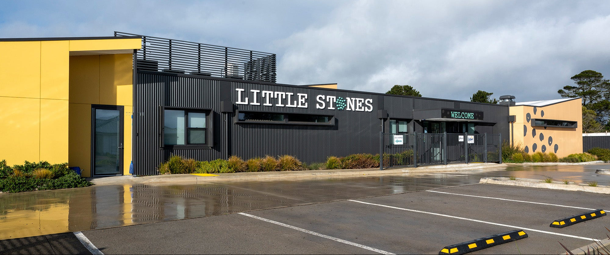 Building with 'Little Stones' sign  in Romsey, on a cloudy day. Produced and installed to corrugated walls by Anytime Signs 