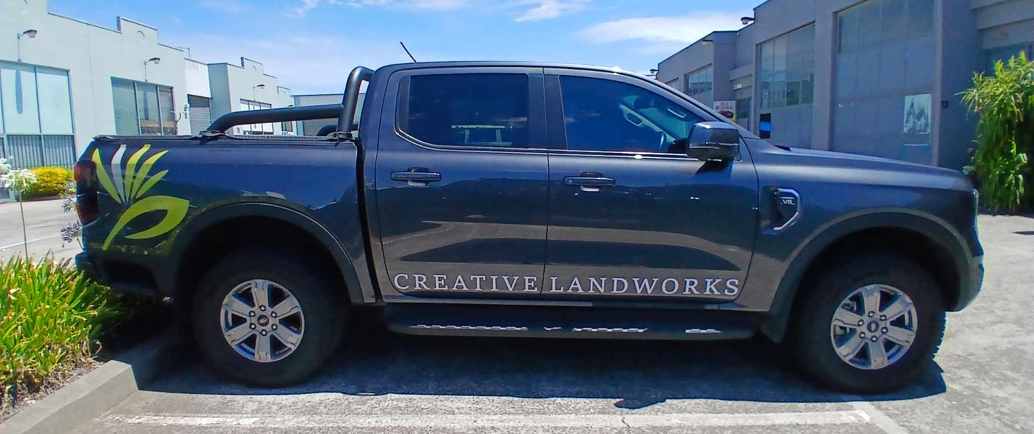 Gray pickup truck with 'Creative Landworks' branding parked in a lot.