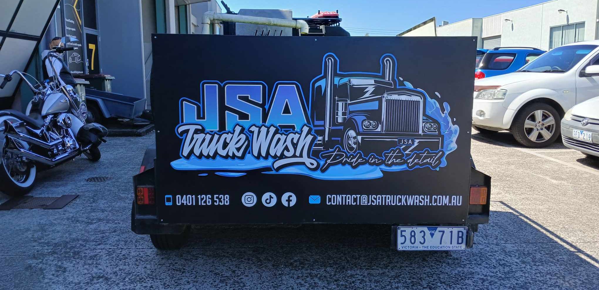 Truckwash trailer used to carry equipment and has the logo in blue.