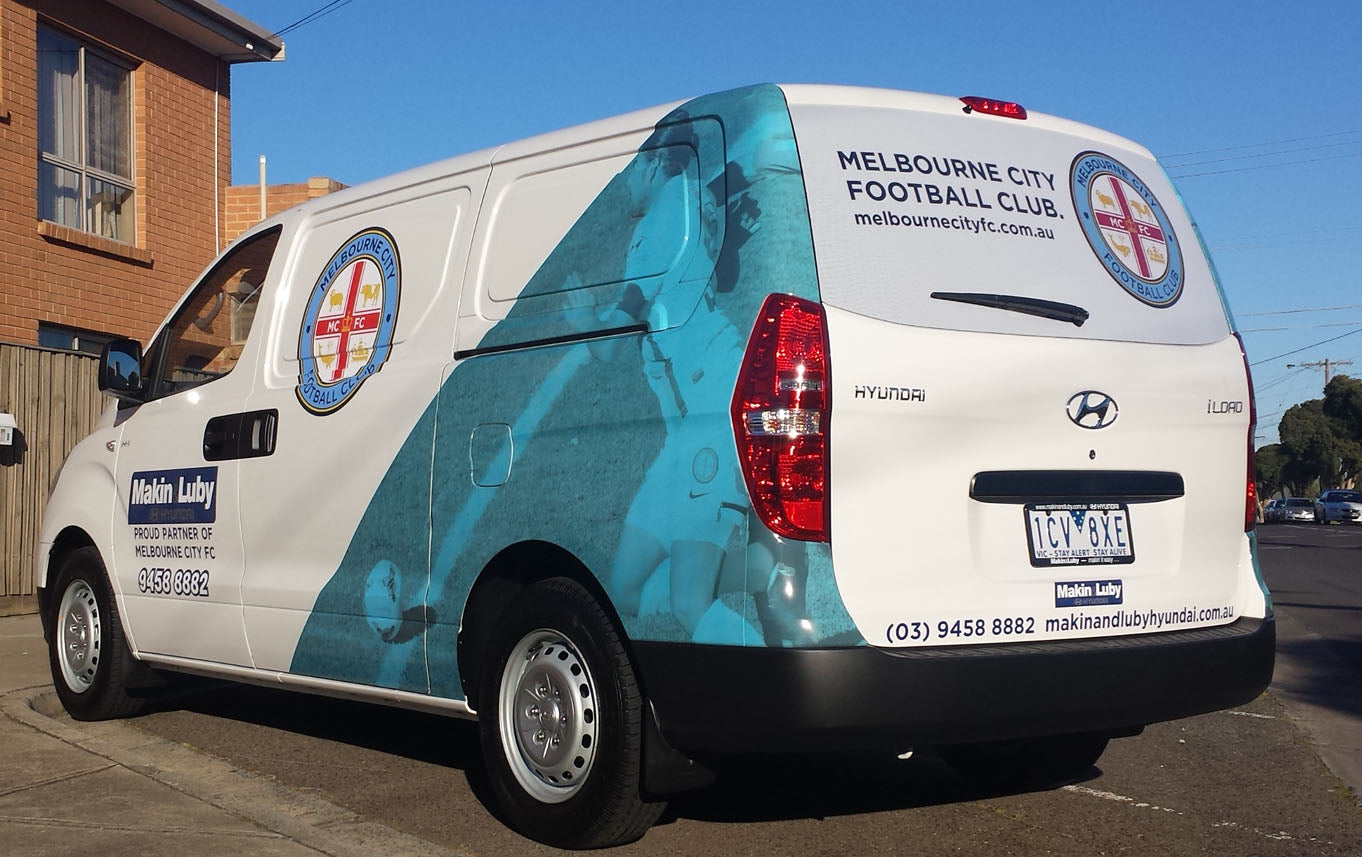 Van with Melbourne City Football Club branding on a street.